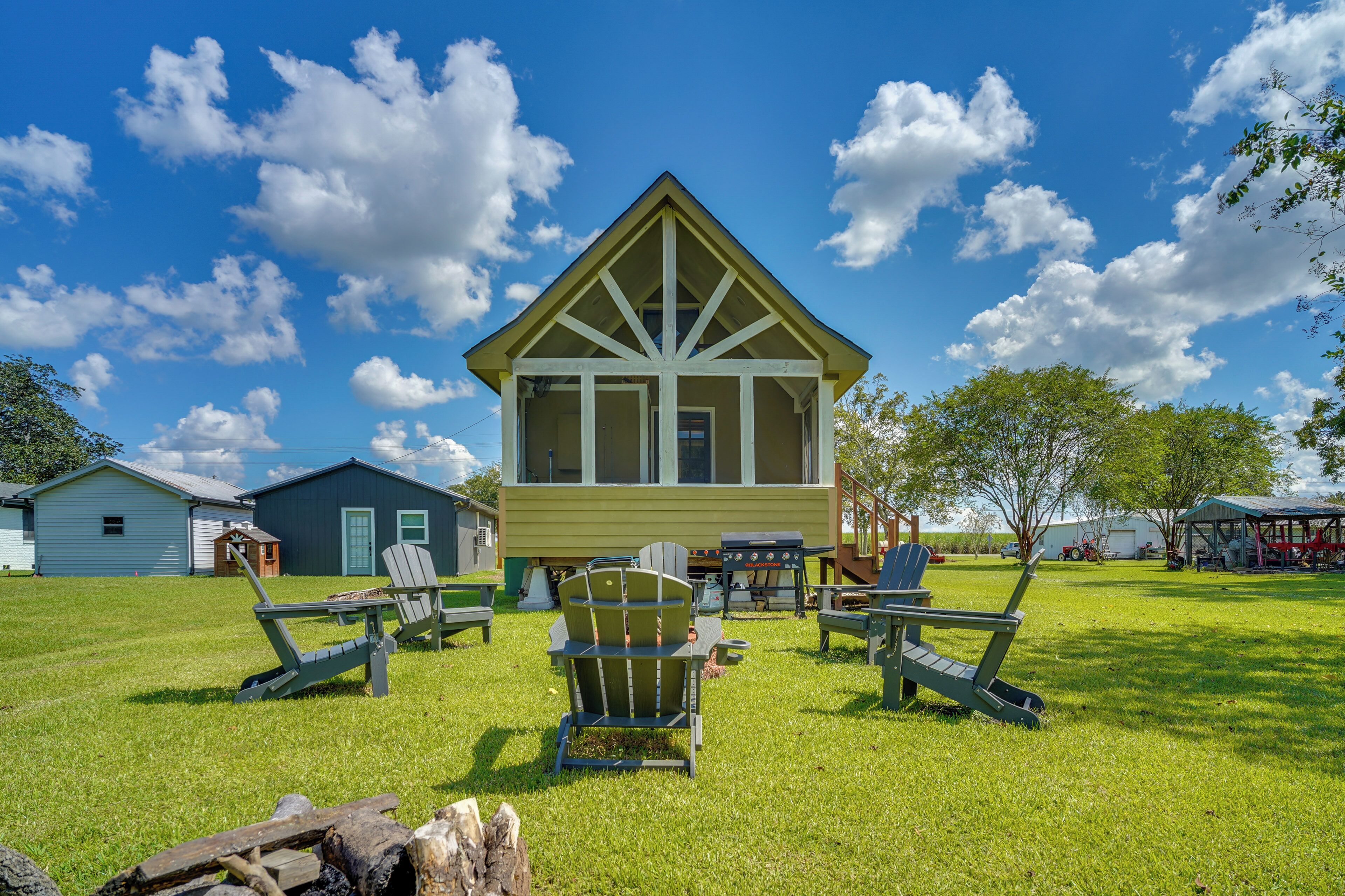 A lodge with a large window, a deck, and outdoor seating.
