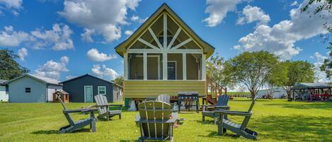 A lodge with a large window, a deck, and outdoor seating.