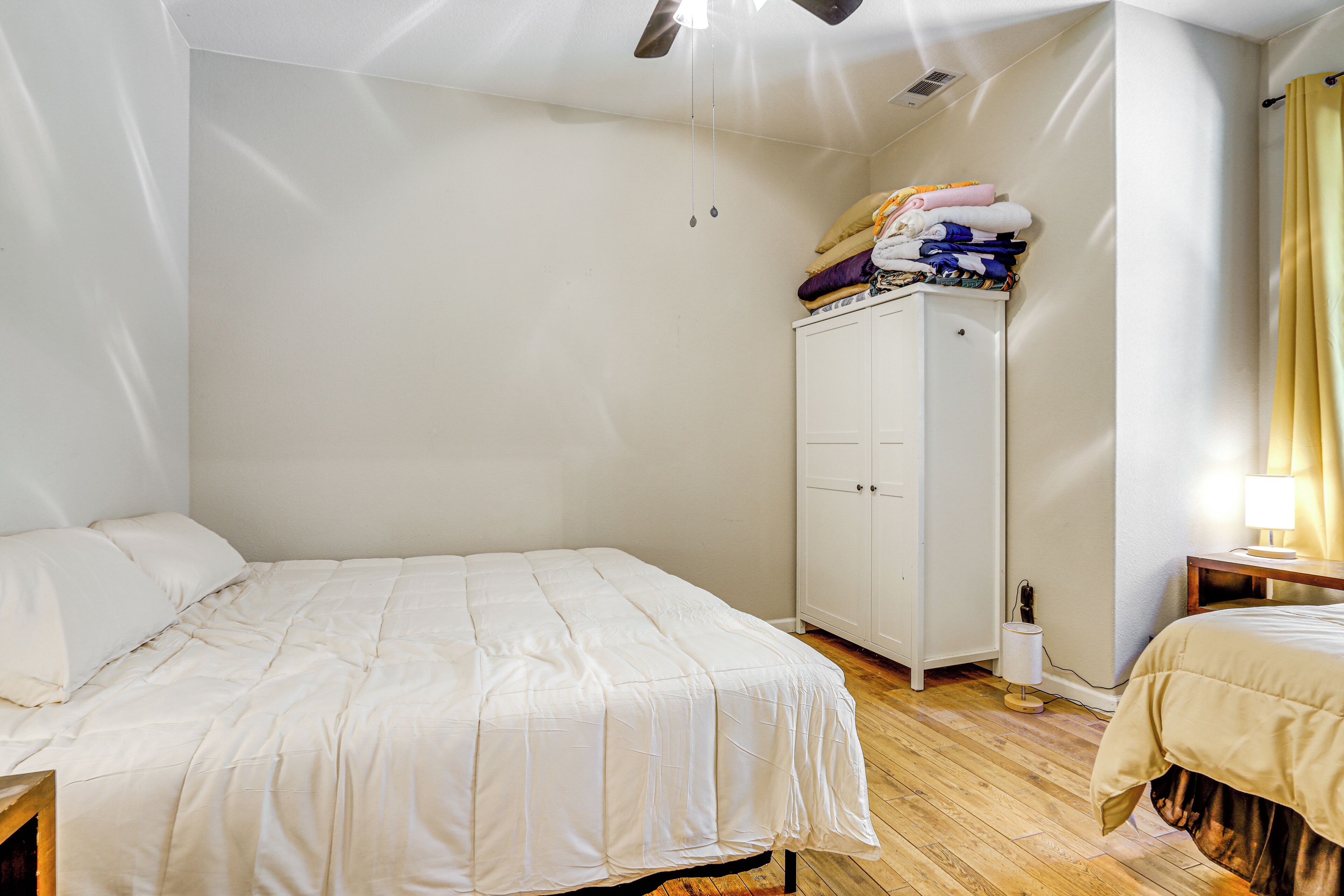 A bedroom with a bed, a wardrobe, and a nightstand.