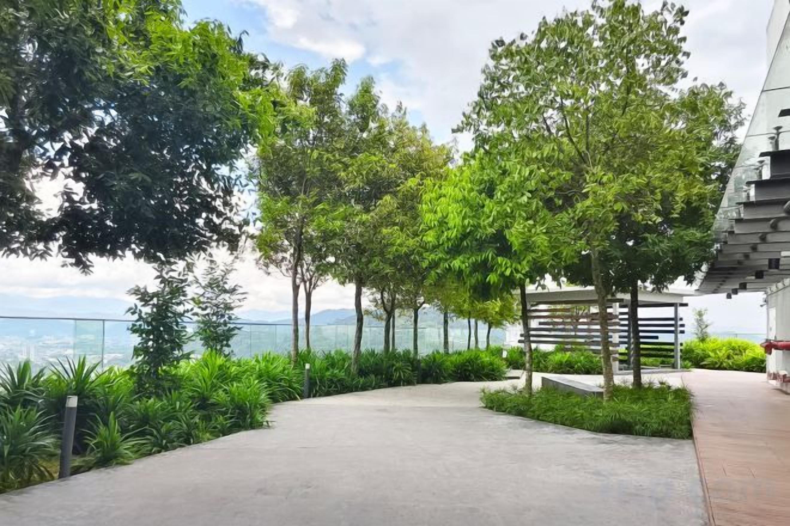 Ein gepflasterter Weg mit Grünflächen und Blick auf die Stadt.