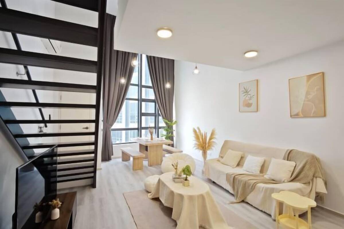 A modern living room with a sofa, coffee table, and a staircase.
