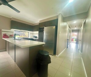 A modern kitchen with a central island, a refrigerator, and a microwave.