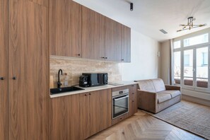 Eine moderne Küche mit Holzschränken, einem eingebauten Ofen und einer Kaffeemaschine.