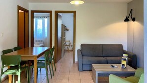A living room with a sofa, a coffee table, and a dining area with a table and chairs. - Ground floor 2 (Propriano)