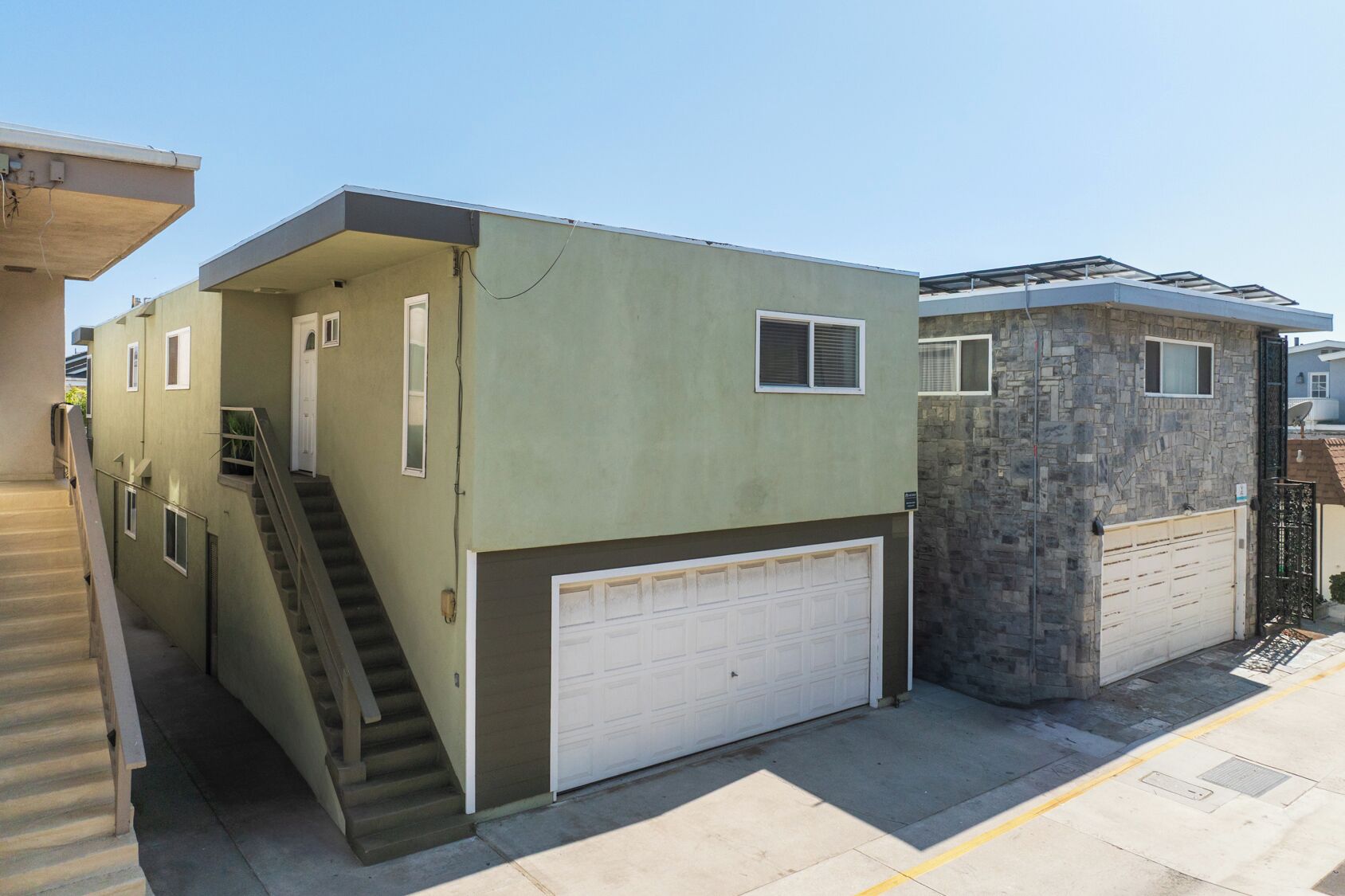 A two-story building with a garage and a small attached structure.
