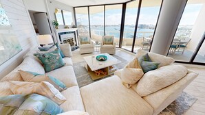 A modern living room with a large window overlooking a marina and cityscape. - East Pass Towers 602 3 Bedroom Condo (Destin)