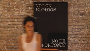 A workspace with a brick wall, a sign reading "NOT ON VACATION," and a laptop on a desk. - Outsite Barcelona - Work, Connect, Explore (Barcelona)