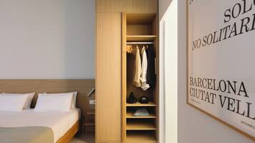 Un dormitorio con una cama de madera, un armario con ropa colgada y una pared con texto.