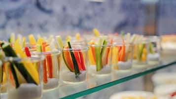 A buffet with various food items in clear glasses.
