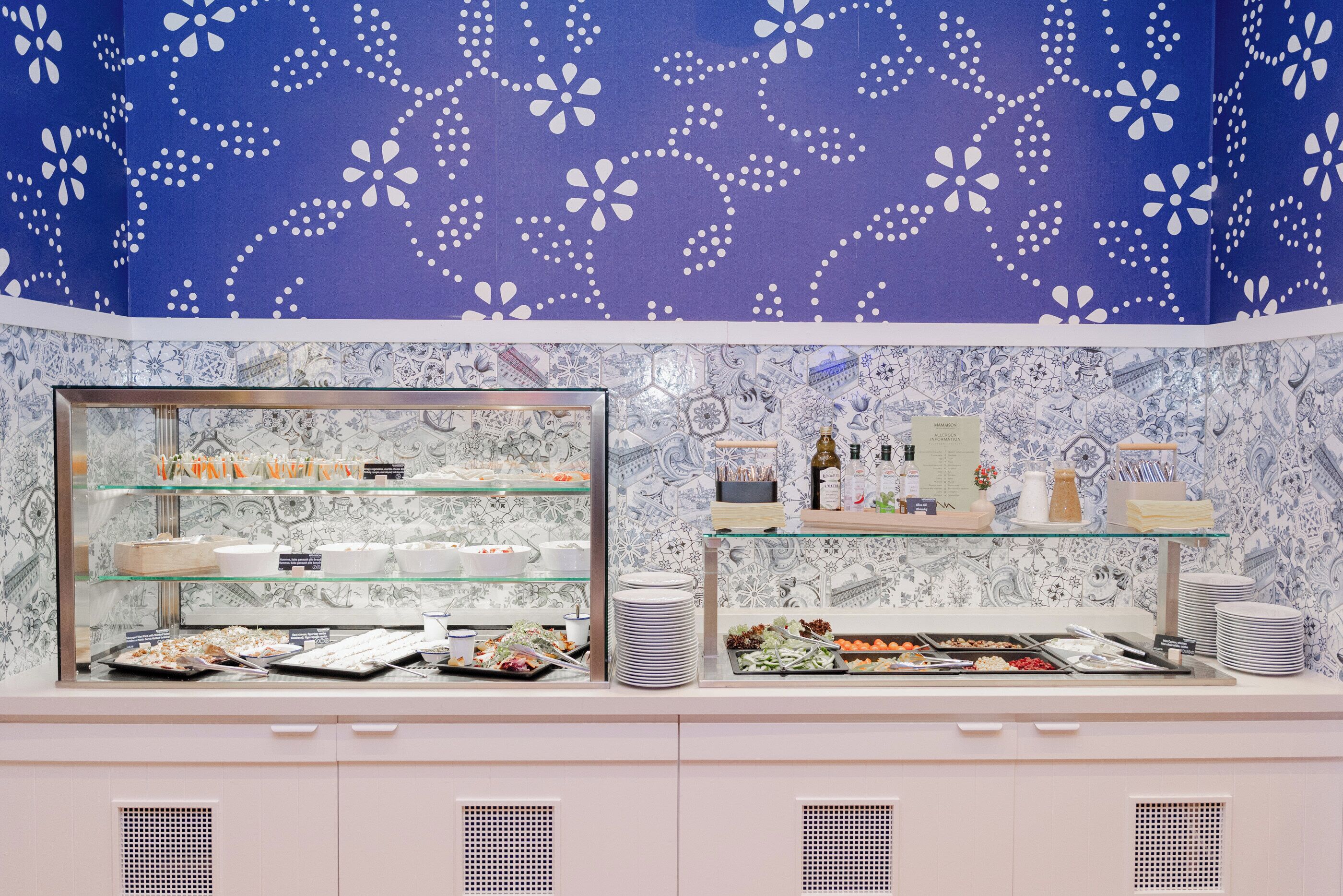 Zona de buffet con vitrinas de vidrio y pared decorada.