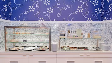 Zona de buffet con vitrinas de vidrio y pared decorada.