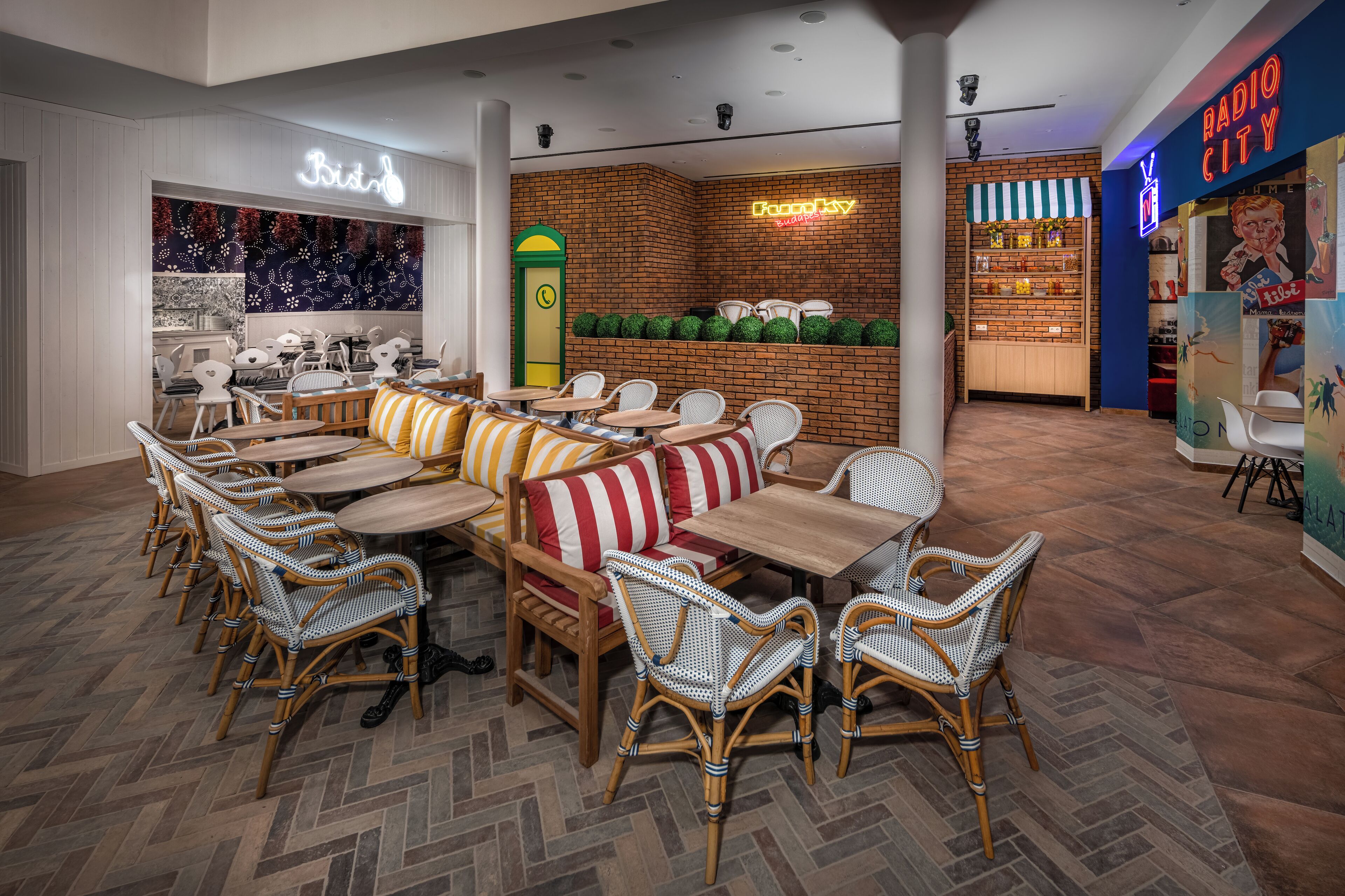 Un ristorante con sedie in vimini, tavoli di legno e cuscini a righe.