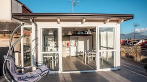 A compact, modern home with a kitchen, dining area, and a small balcony with a hanging chair. - Solarium al Duomo Rooms by Wonderful Italy (Naples)