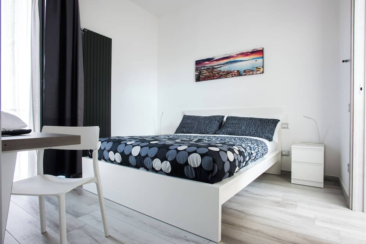 A modern bedroom with a bed, a desk, and a chair.