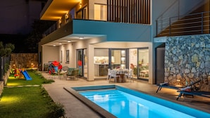 A modern house with a swimming pool, outdoor seating, and a children's play area. - Vila SUNLIFE with pool&sauna by Villas Guide (Matulji)