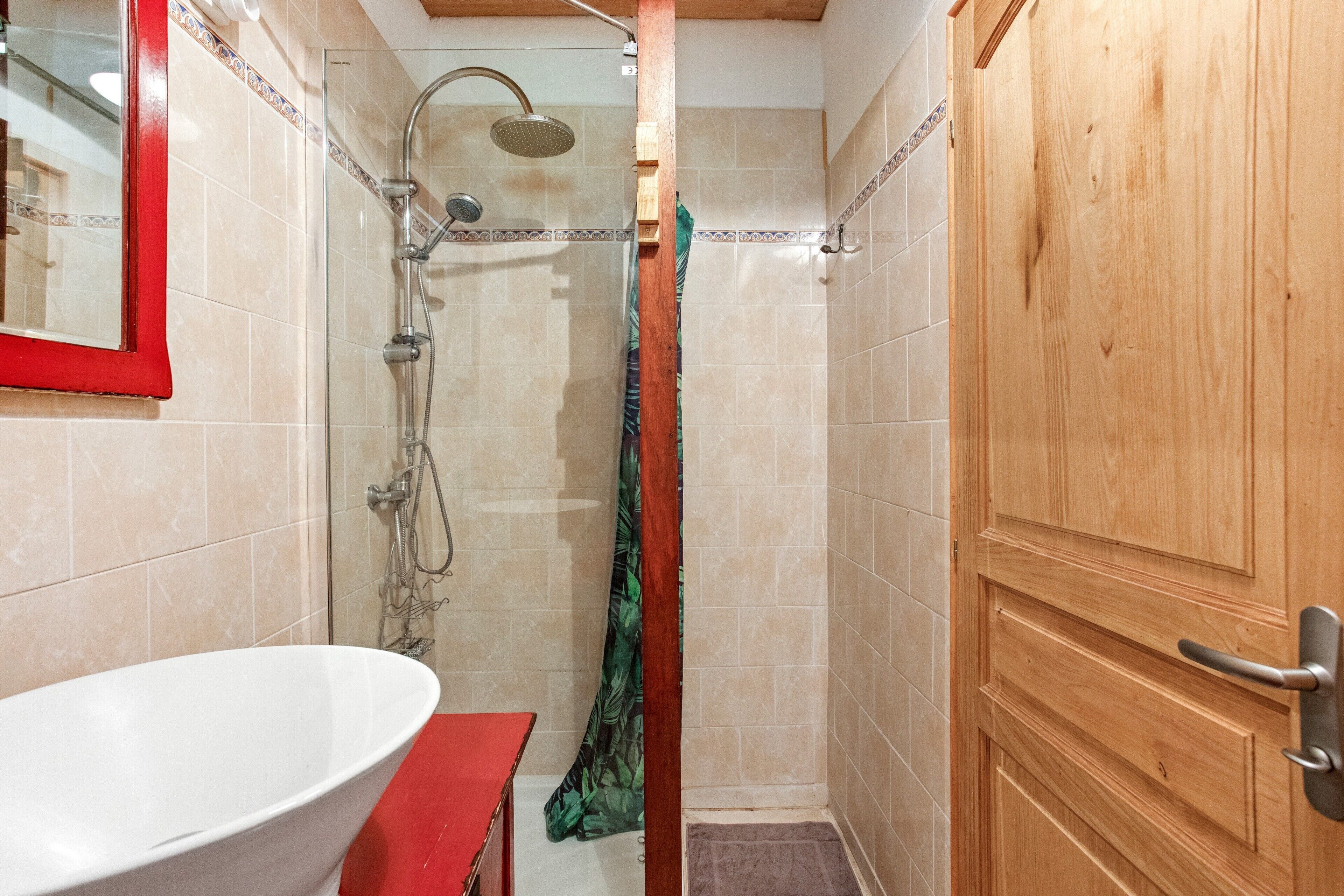 Ein Badezimmer mit Badewanne, Dusche und Holztür.