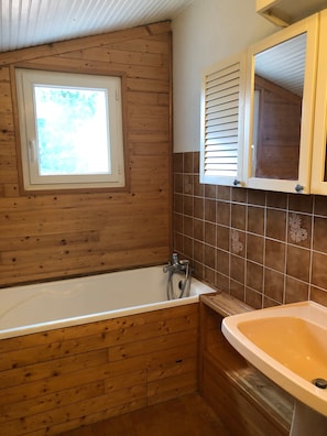 A wooden-paneled bathroom with a bathtub, a sink, and a window. - Guest Room "Le Pommier" with Private Terrace, Shared Garden & Wi-Fi in Royan (Royan)