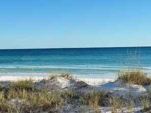 A beach with clear blue water and sand dunes. - Waterfront Playground in Paradise - more than a condo rental, a destination! (Destin)