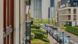 A modern building with a distinctive dome and a parking lot with cars.