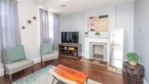 A living room with a fireplace, a television, and two sofas.