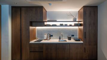 Deluxe Studio, Garden View | Private kitchen | Stovetop, dishwasher, cookware/dishes/utensils, dining tables