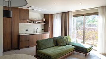 A modern kitchen with wooden cabinets, a built-in island, and a large window with curtains.