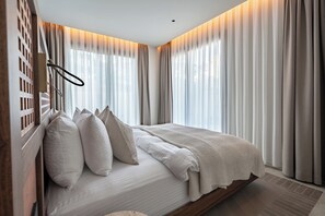 Un dormitorio con cama, cortinas y cabecero de madera.