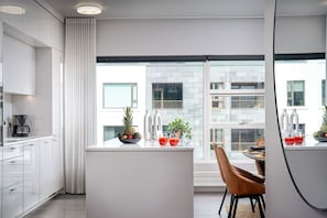 Una cocina moderna con comedor, ventanas amplias y vistas a la ciudad.