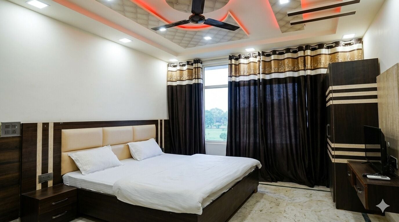 Un dormitorio con cama, mesitas de noche, escritorio, ventilador de techo y cortinas.