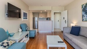 Una sala de estar moderna con un sofá, una mesa de centro y un televisor.
