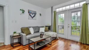 A modern living room with a grey sofa, a coffee table, and a large window with curtains. - Victorian house (Sydney)