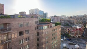 Un immeuble de grande hauteur doté de nombreux balcons et d’un jardin sur le toit.