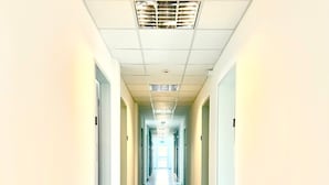 A long, narrow hallway with a tiled floor and white walls. - Donau-Iller Vermietung 24  (Neu-Ulm)