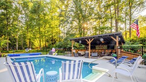 A pool area with lounge chairs and a covered seating area. - Pool, Pickleball, Poker, Ping-Pong! King beds! (Greer)