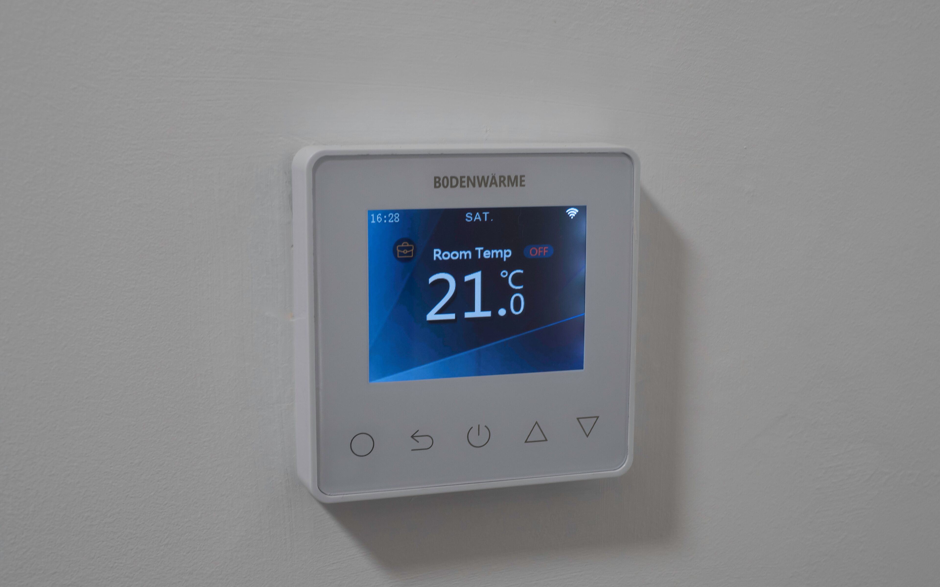 A digital thermostat displaying room temperature.