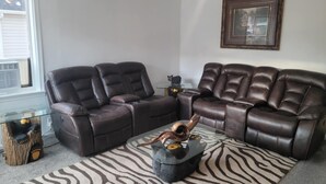 A living room with a brown leather sectional sofa, a glass coffee table with a zebra print rug, and a framed picture on the wall. - Ridgeline #1 Unique 2 bedroom house in Helper. (Helper)