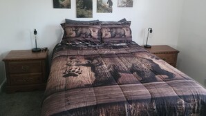 A bedroom with a large bed, two bedside tables, and three wall-mounted paintings. - Ridgeline #1 Unique 2 bedroom house in Helper. (Helper)
