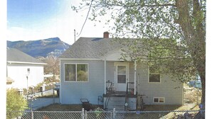 A single-story house with a front porch, a garage, and a fenced yard. - Ridgeline #1 Unique 2 bedroom house in Helper. (Helper)