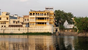 Un immeuble à plusieurs étages, doté de balcons, dont le reflet se mire dans l’eau.