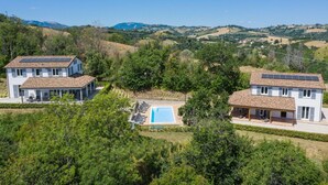 Ein zweigeschossiges Haus mit Swimmingpool und Solaranlage.