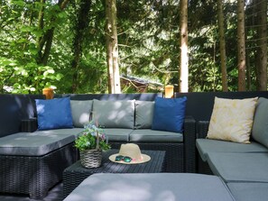 An outdoor seating area with a sofa and chairs, surrounded by trees. - Feather Hill Lodge White Cross Bay, Skiptory Howe 38 (Windermere)