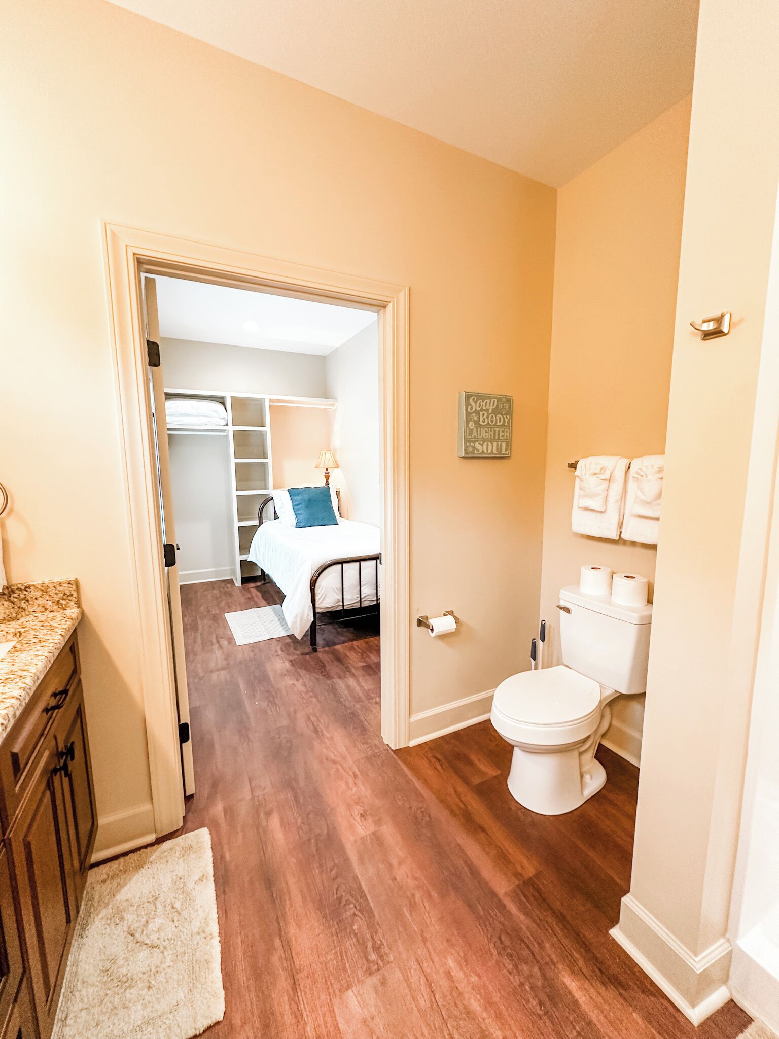 Een badkamer met toilet, wastafel en handdoekhouder.