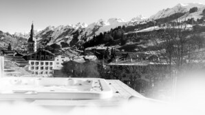 A mountainous town with a church, residential buildings, and a hot tub area.