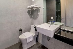 A modern bathroom with a toilet, sink, and shower. - Vasaka Hotel Makassar (Rappocini)