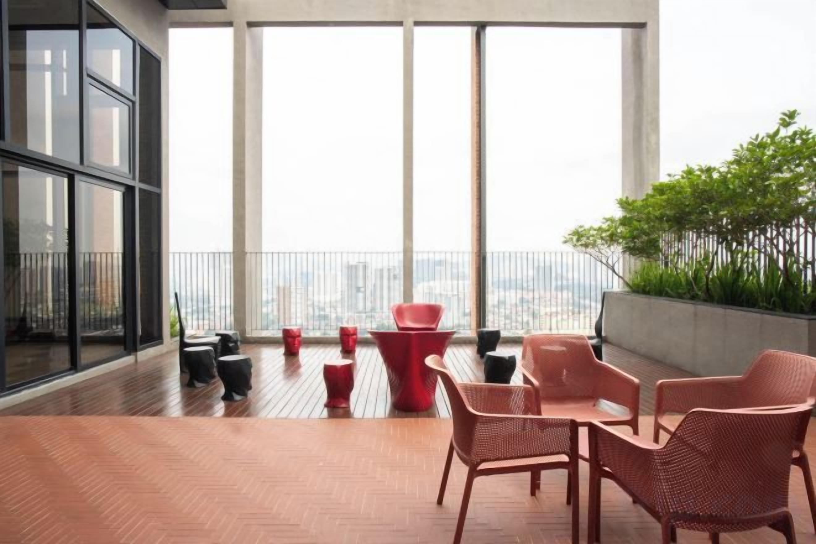 Ein moderner Balkon mit Korbmöbeln und Blick auf die Stadt.