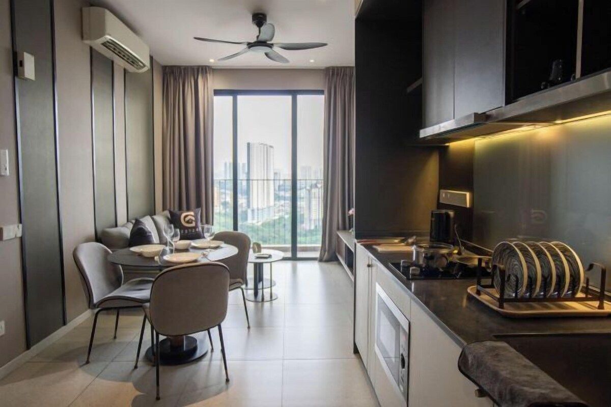 Una cocina moderna con estufa integrada, una zona de comedor con mesa redonda y sillas, y un ventanal con cortinas.