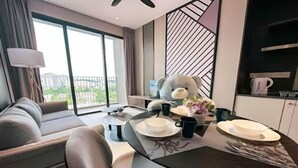 Una sala de estar moderna con un sofá, una mesa de comedor dispuesta con platos y tazas, y un osito de peluche.