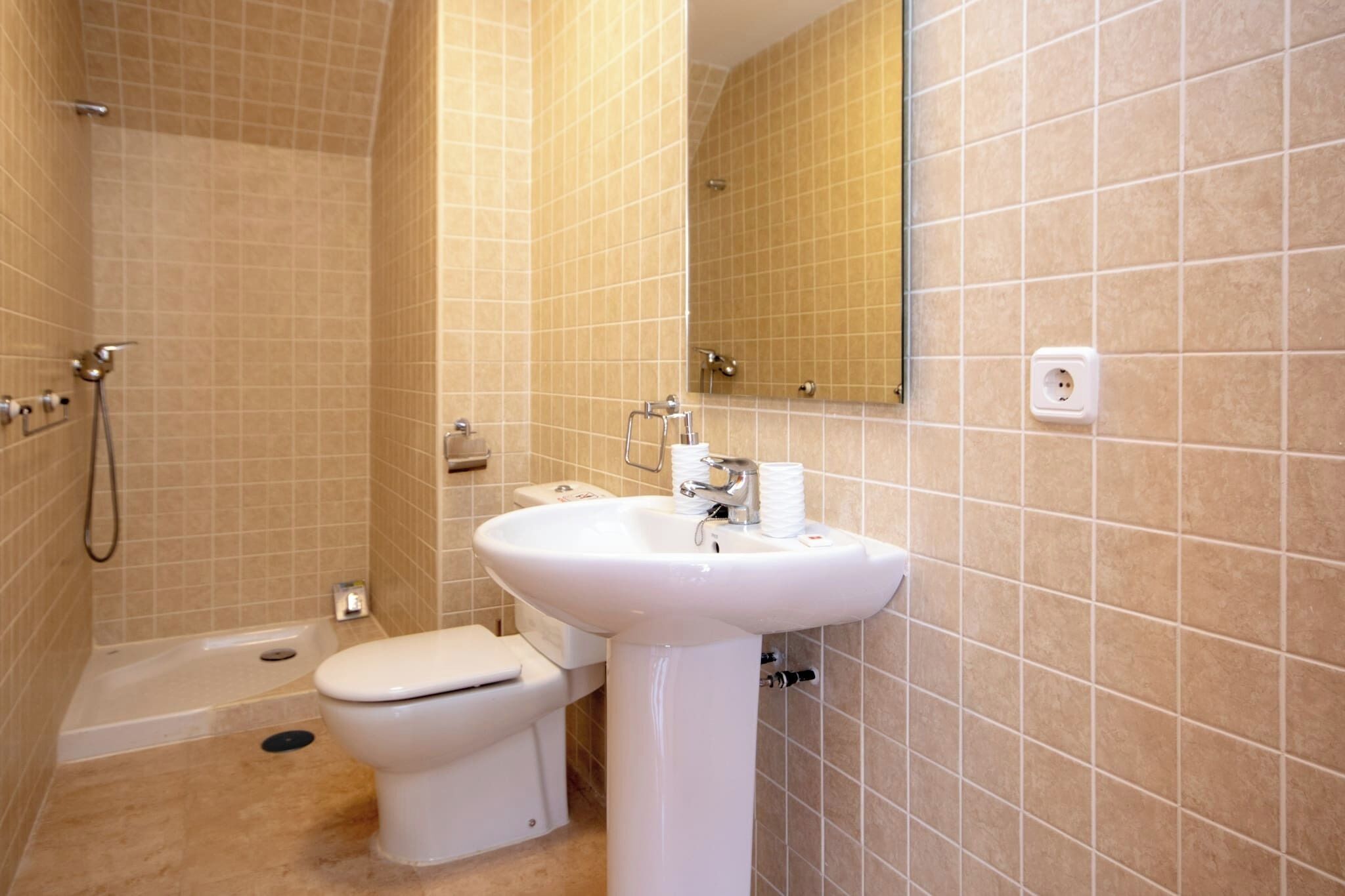 A bathroom with a toilet, sink, and shower.