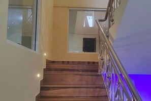 A staircase with a metal railing and a glass door at the top. - Villa Infinity Negombo (Negombo)