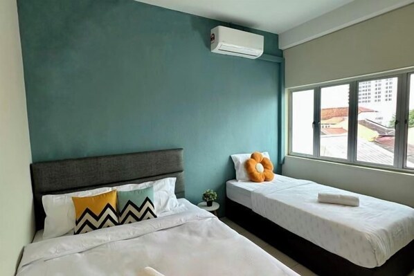 A hotel room with two beds, a window, and an air conditioning unit. - Swing & Pillows at Penang Road, Georgetown (Northeast Penang Island)